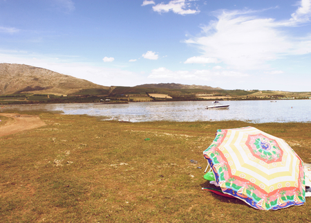 One umbrella on the grass by lake in natureの写真素材