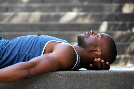 Side portrait of an african american man sleeping outsideの写真素材