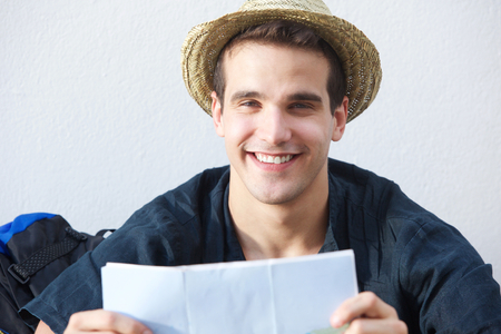 Close up portrait of a smiling traveling man with mapの写真素材