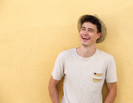Portrait of a handsome young man with hat laughing