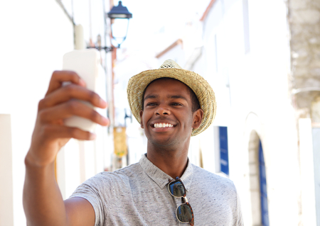 Smiling young man taking selfie on vacationの写真素材