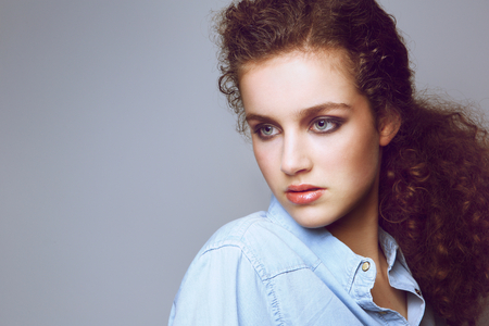 Close up portrait of an attractive young fashion model with curly hairの写真素材