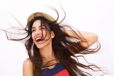 Portrait of a smiling young woman with long hair blowing in the windの写真素材