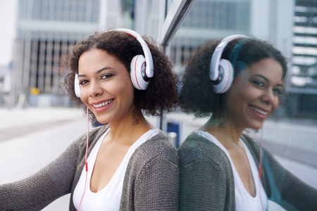Close up portrait of a girl sitting and listening to music on headphonesの写真素材