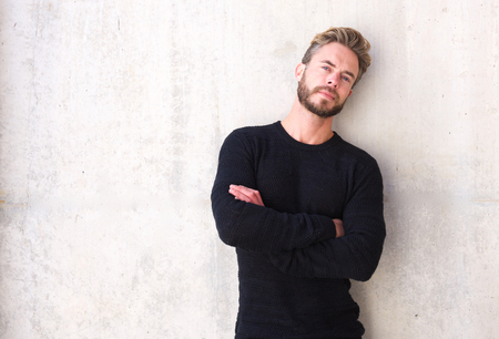 Portrait of a male fashion model with beard posing with arms crossedの写真素材