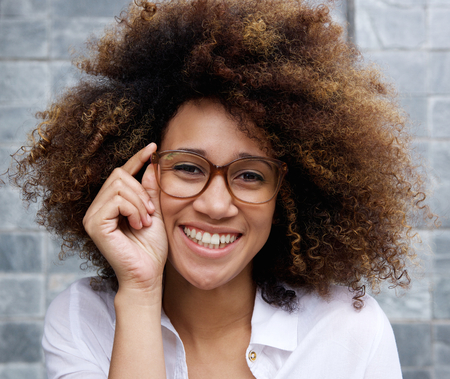 Portrait of an smiling woman with afro and glassesの写真素材