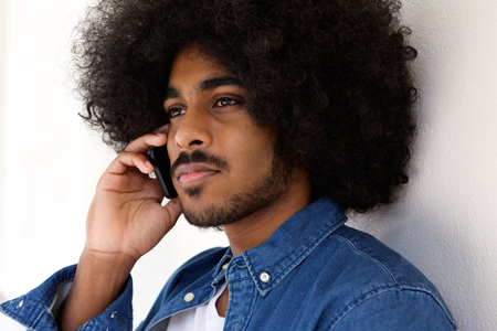 Close up portrait of a cool modern guy using cell phoneの写真素材