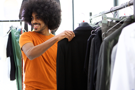 Smiling male shopper looking for clothesの写真素材