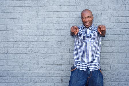 Portrait of cheerful young african man pointing fingerの写真素材
