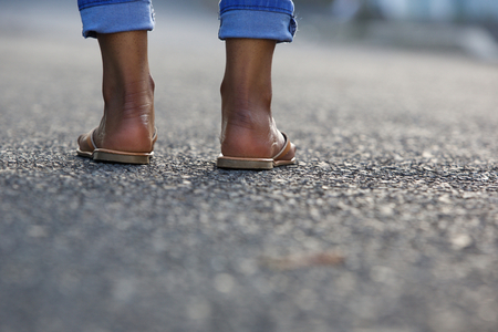 Close up portrait of a young woman legs standing on city streetの写真素材