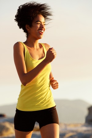 Portrait of a smiling sports woman running outdoors