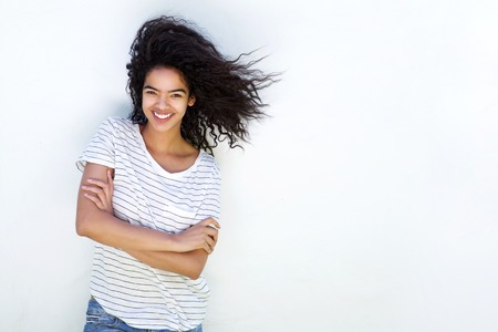Portrait of a smiling young mixed race girl against white backgroundの写真素材