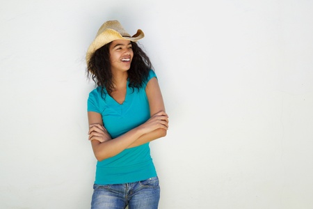 Portrait of a beautiful mixed race girl with hat smiling against white backgroundの写真素材