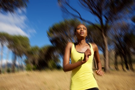 Portrait of healthy young african woman running outdoorsの写真素材