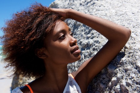 Close up portrait of a young african american woman posing outdoors with her hand in hairの写真素材