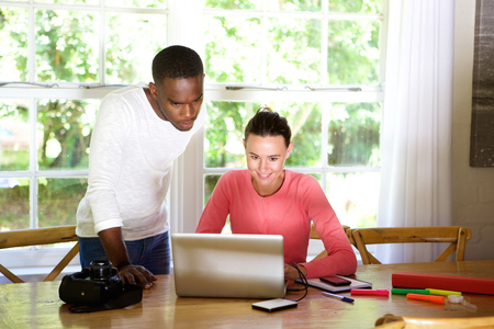 Portrait of two young photo artists using a laptop