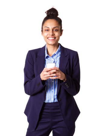 Portrait of confident young business woman with mobile phone against white backgroundの写真素材