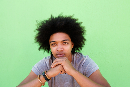 Close up portrait of a cool guy with afro against green backgroundの写真素材