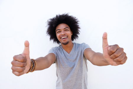 Close up portrait of a smiling young man with afro showing thumbs upの写真素材