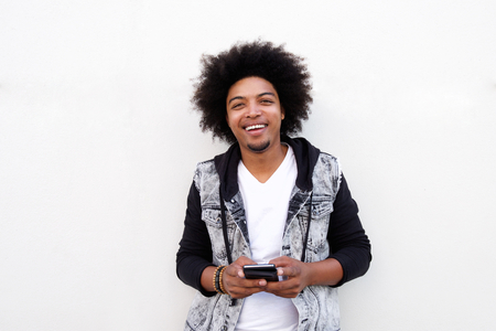 Portrait of a cool black guy holding cell phone against white backgroundの写真素材