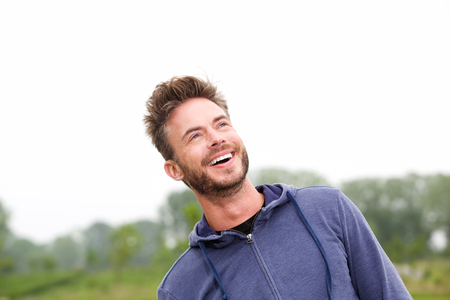 Close up portrait of cheerful athlete standing in park