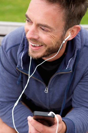 Portrait of happy jogger sitting with headphonesの写真素材