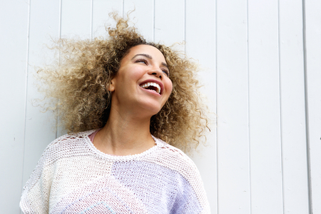 Close up portrait of smiling young woman with hair blowing in windの写真素材