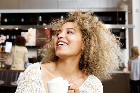 Close up portrait of cheerful young woman in cafeの写真素材
