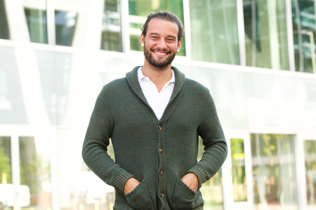 Portrait of cool guy with beard smiling outside