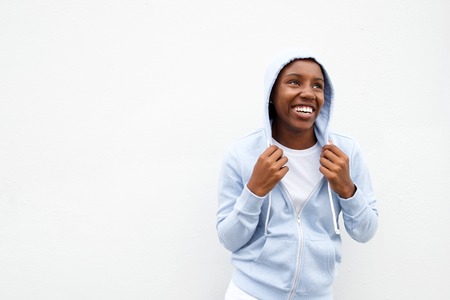 Portrait of young african woman keeping warm in comfortable hoodie looking up.の写真素材