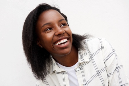 Closeup portrait of african woman looking away laughing.の写真素材