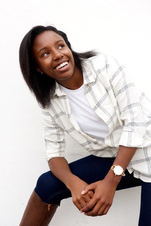 Portrait of happy african woman sitting and looking up smiling.の写真素材