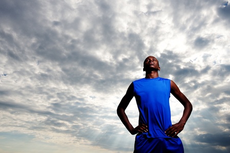 Low angle portrait of confident and fit african man standing with hands on hipsの写真素材
