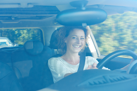 Portrait of smiling older woman in car on commute
