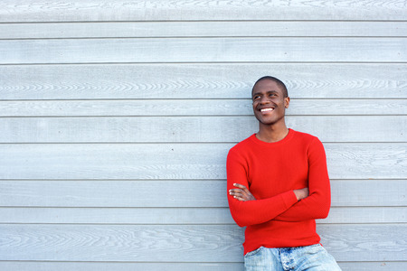 Portrait of a cool young black guy smiling with red sweaterの写真素材