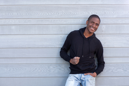 Portrait of a cool young black guy smiling with black sweatshirtの写真素材