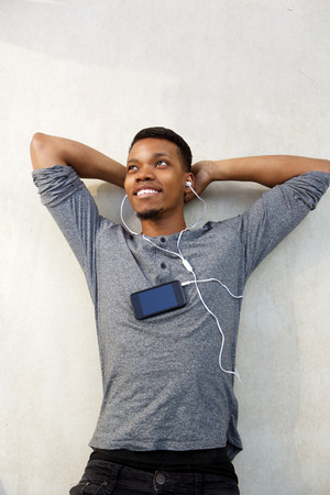 Aerial portrait of attractive man lying down with cellphone and earphonesの写真素材