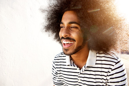 Close up portrait of laughing afro man in sunlightの写真素材