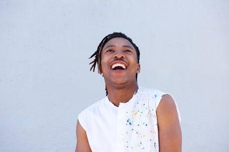 Portrait of african man with dreadlocks laughing and looking upの写真素材