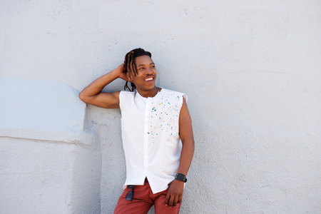 Portrait of cool african guy leaning against gray wallの写真素材