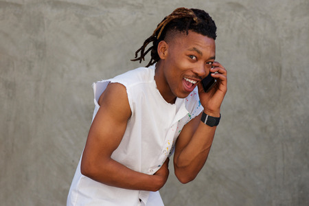 Portrait of african man  laughing and talking on mobile phoneの写真素材