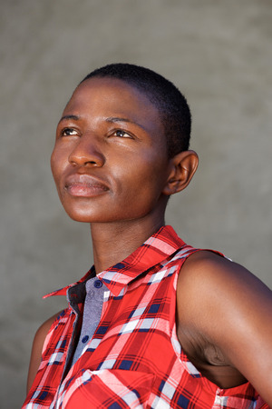 Close up portrait of serious beautiful woman wearing plaid shirt by wallの写真素材