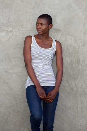 Portrait of attractive woman standing against wall outside looking thoughtfulの写真素材