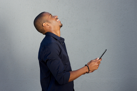 Portrait of african american man laughing with digital tabletの写真素材
