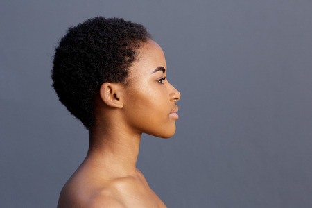 Close up profile portrait of african american young woman against gray backgroundの写真素材