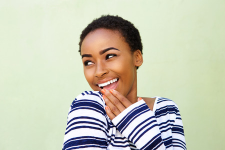 Portrait of smiling young woman with hand over mouth