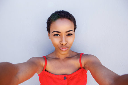 Portrait of cool young african american woman taking selfieの写真素材