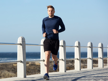 Full body portrait of healthy young man going for a run outside