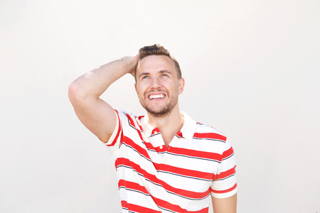 Portrait of happy young man smiling with hand in hairの写真素材