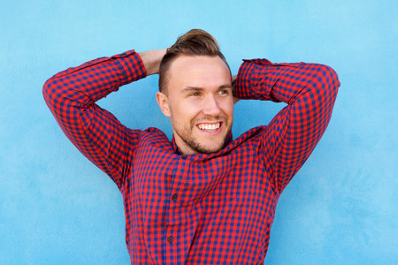 Portrait of happy guy smiling with hands behind headの写真素材
